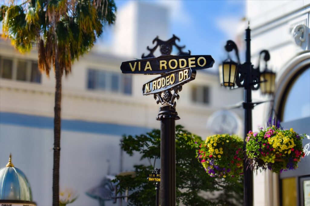 A street sign for the intersection of Via Rodeo Drive and North Rodeo Drive in Beverly Hills, CA.